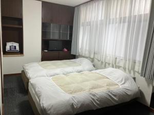 Een bed of bedden in een kamer bij Marina Bay Atami
