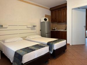 a kitchen with two beds and a refrigerator at EURO HOUSE INN airport in Fiumicino