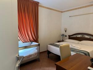 a hotel room with two beds and a table at EURO HOUSE INN airport in Fiumicino