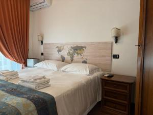 a bedroom with a bed with towels on it at EURO HOUSE INN airport in Fiumicino