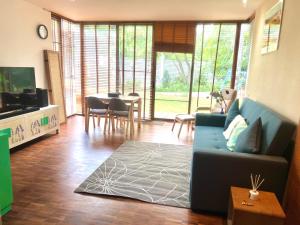 Bang SuThe Oasis Ari的客厅里有一张蓝色的沙发和一张桌子