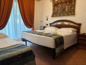 a bedroom with two beds and a painting on the wall at EURO HOUSE INN airport in Fiumicino