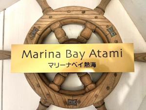 een bord waarop staat Marina Bay Atkin op een houten wiel bij Marina Bay Atami in Atami