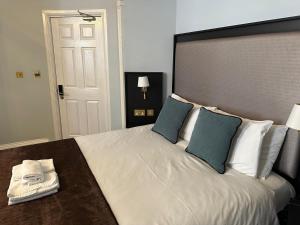 a bedroom with a large white bed with blue pillows at Arran House Hotel in London
