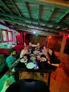 a group of people sitting at a table eating food at HOME HOSTEL ELLA private rooms only in Ella