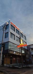 AmbikāpurにあるHOTEL SIGNATURE INNの前に看板がある白い建物