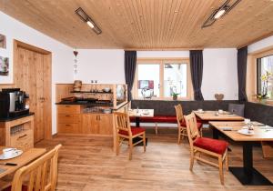a dining room with wooden tables and chairs at Pension Alpenfeeling in Pfronten