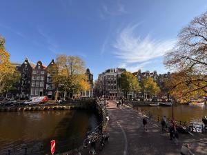 a group of people walking on a sidewalk next to a river at Décor Canal House in Amsterdam