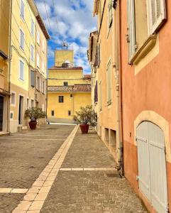 an empty alley in a city with buildings at Bandol plage port in Bandol