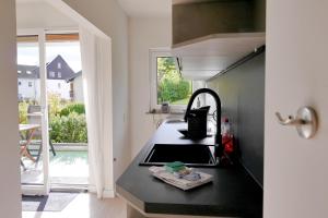 a kitchen with a black counter top and a sink at Ferienwohnung beim Skihang in Willingen