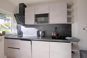 a kitchen with white cabinets and a black counter top at Ferienwohnung beim Skihang in Willingen +22 photos