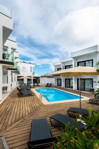 an outdoor deck with chairs and a swimming pool at Saladar Suites Boutique in Morro del Jable