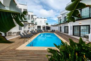 a pool on the deck of a building with chairs at Saladar Suites Boutique in Morro del Jable