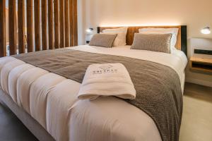 a bedroom with a large bed with white sheets and pillows at Saladar Suites Boutique in Morro del Jable