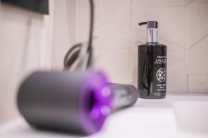 a black electric toothbrush sitting next to a bottle of soap at Saladar Suites Boutique in Morro del Jable
