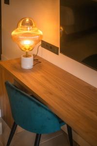 a table with a lamp and a blue chair at Saladar Suites Boutique in Morro del Jable