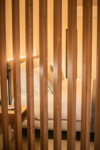 a view of a bed through a wooden fence at Saladar Suites Boutique in Morro del Jable