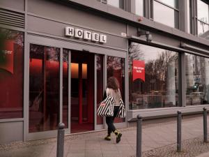 a woman walking in front of a store at Casa Camper Berlin in Berlin