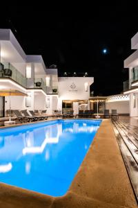 a large swimming pool with blue water at night at Saladar Suites Boutique in Morro del Jable