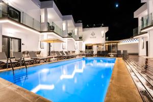 a swimming pool at night with chairs and umbrellas at Saladar Suites Boutique in Morro del Jable