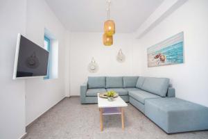 a living room with a blue couch and a table at Villa Kalathos Dream White in Kalathos