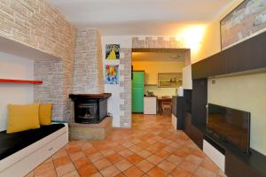 sala de estar con chimenea y pared de ladrillo en Villa Agello con Idromassaggio, en Agello