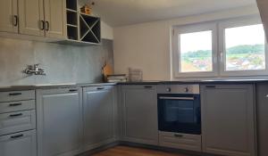 a kitchen with white cabinets and a sink and a window at Ferienwohnung Macht in Furth im Wald +17 photos