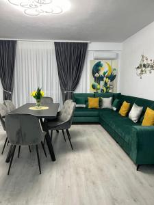 a living room with a green couch and a table at cris residence in Alba Iulia