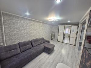 a living room with a brown couch in a room at 1-ком апартаменты Comfort Plus Elita in Petropavlovsk