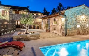 a house with a swimming pool and a building at Rustic stone holiday house with pool in Marčana