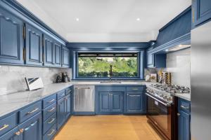 a blue kitchen with a sink and a window at Beverly Tree House in Los Angeles