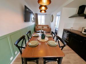 een eettafel met stoelen en een keuken bij D-Day Suites in Carentan