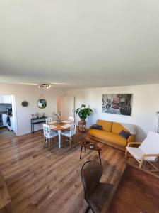 a living room with a yellow couch and a table at Chez Marie et Ludovic in Ronchin +15 photos
