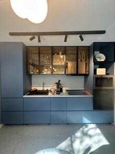 a blue kitchen with a sink and a refrigerator at Alpin Heaven in Dâmbovicioara