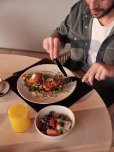 a man sitting at a table with a plate of food at Casa Camper Berlin in Berlin