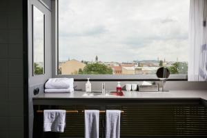 a bathroom with a sink and a window with towels at Casa Camper Berlin in Berlin