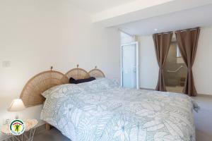 a bedroom with a bed with a blue and white bedspread at Gîte des Mouliniers in Saint-Siméon-de-Bressieux