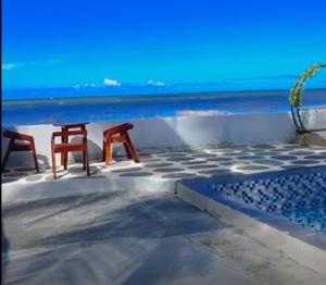 two chairs sitting on a patio overlooking the ocean at Kopap Villa in Lalonggasumeto +4 photos