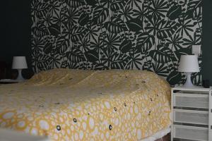 a bedroom with a bed with a black and white wallpaper at Maison douillette à 600m de la plage in Saint-Michel-Chef-Chef +3 photos