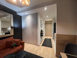 a living room with a couch and a clock on the wall at Belgrade Waterfront Lux Studio Apartment in Belgrade