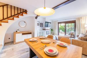 een eetkamer en een woonkamer met een houten tafel bij Casa Jardines del Sol 4 in Marbella