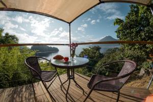 圣马科斯拉拉古纳Fuego Atitlan Eco-Hotel的水景甲板上的桌椅