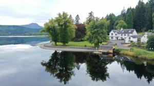 an aerial view of a house and a lake at Altskeith Country House in Aberfoyle