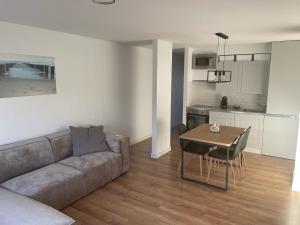 a living room with a couch and a table and a kitchen at Appartement Duin225 in Bredene