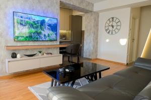 a living room with a couch and a tv on the wall at Luxury living by Dazzie in Skopje