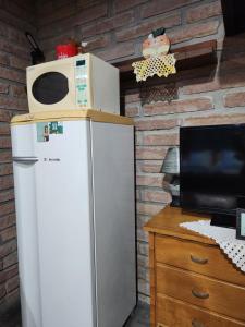 un forno a microonde in cima a un frigorifero in una cucina di Canto do Luar a Santa Cruz do Sul