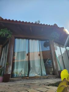 a window of a house with curtains on it at Canto do Luar in Santa Cruz do Sul +13 photos