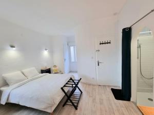 una camera bianca con un grande letto e una doccia di La Chambre Bleue - Chambre avec salle de bain ad Argenton-sur-Creuse