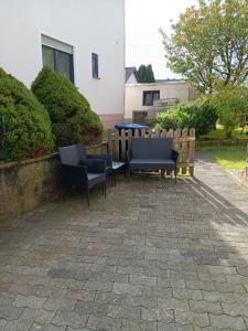 two chairs and a table on a brick patio at Ninas & Andrejs Gästezimmer in Hinterweiler +1 photo