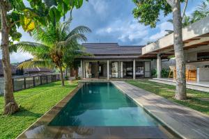 an image of a swimming pool in front of a house at Sola Villa Ubud in Ubud